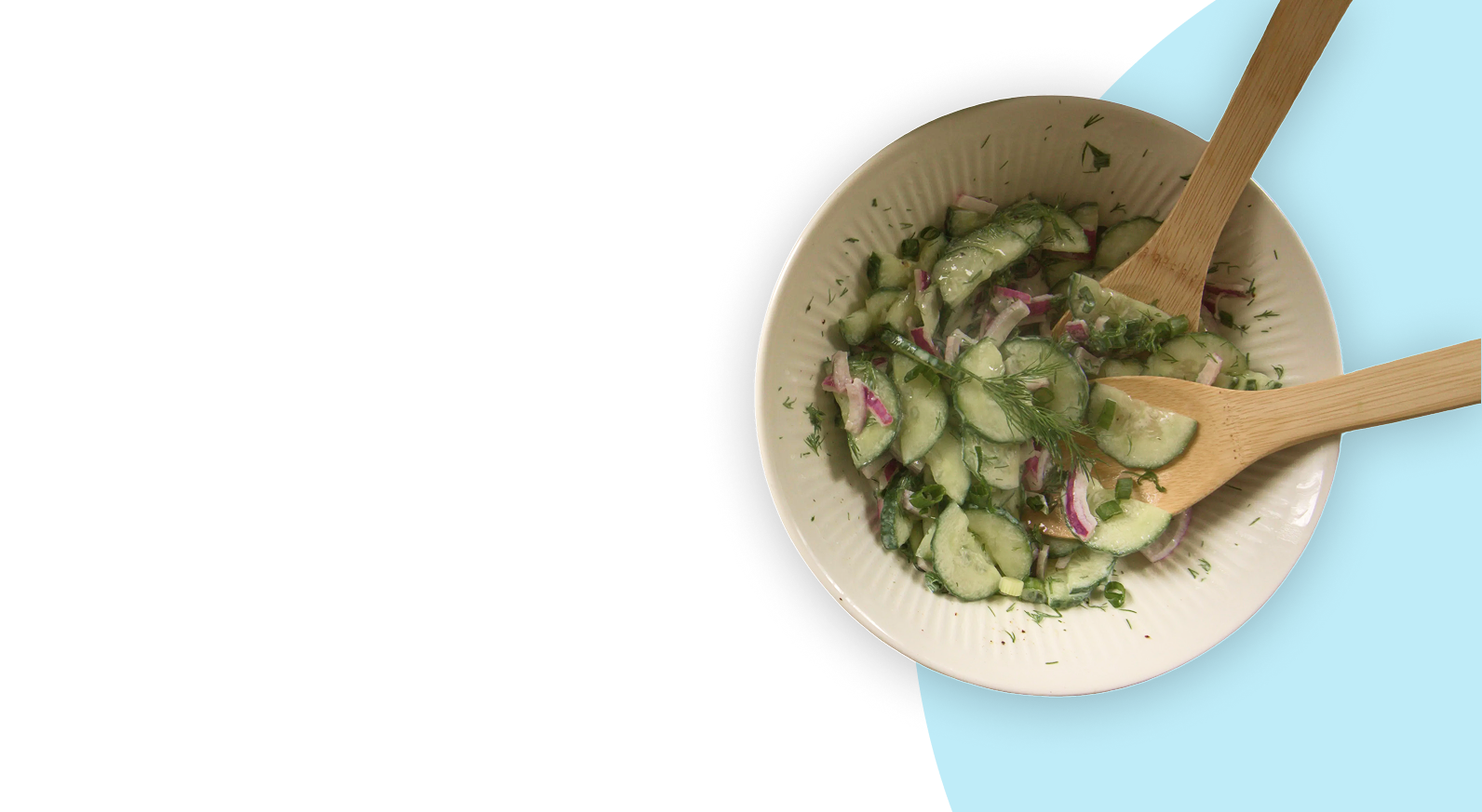 A bowl of fresh cucumber salad with red onion and dill.